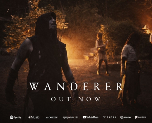 Promotional album cover for Wanderer: a hooded warrior stands by a campfire at night with others in the background; text reads 'WANDERER' and 'OUT NOW'.